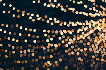 Decorative outdoor string lights at night time, Defocused Background, night city life backdrop, party time with Yellow bokeh balls