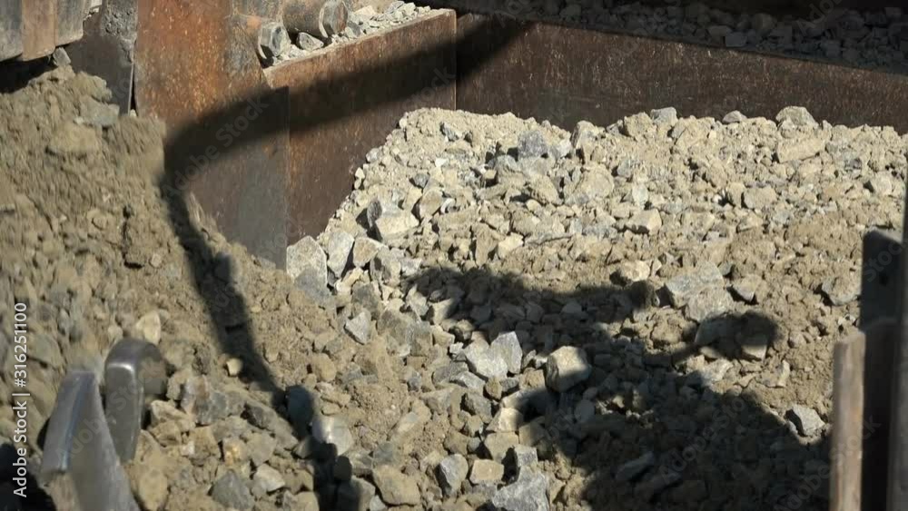 Road machinery that crushes stones and sets it on a country road Road machinery that crushes stones and sets it on a country road