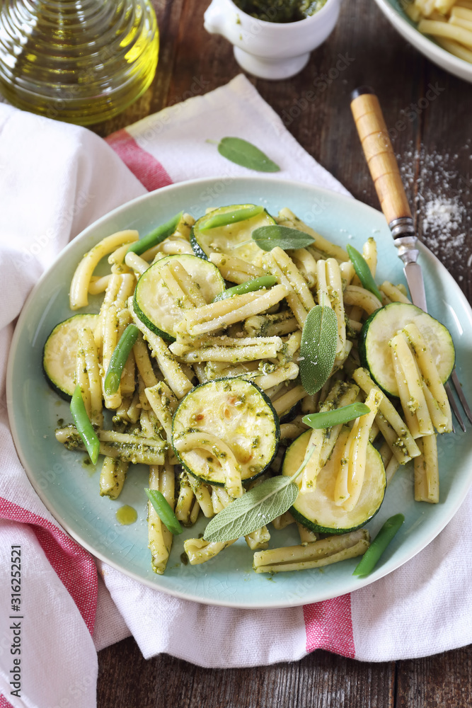 Italian penne pasta with roasted zucchini, pesto sauce and green beans