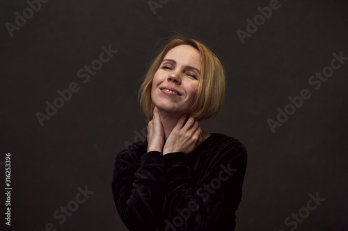 Woman is smiling on a dark background.