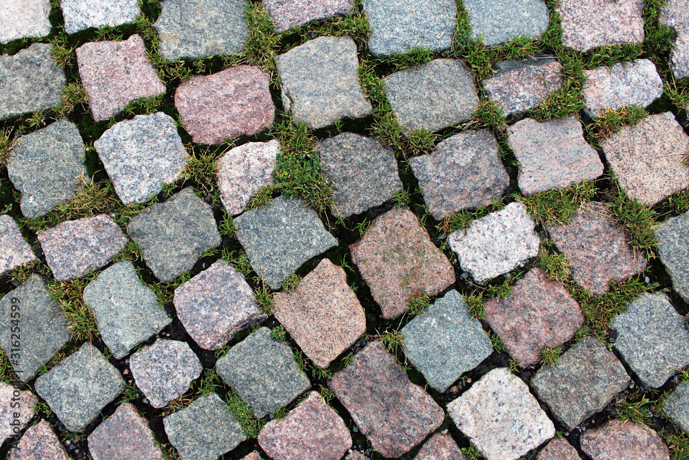 Old cobblestone road with soil between stones. Texture and background. Old cobblestone road with soil between stones. Texture and background.