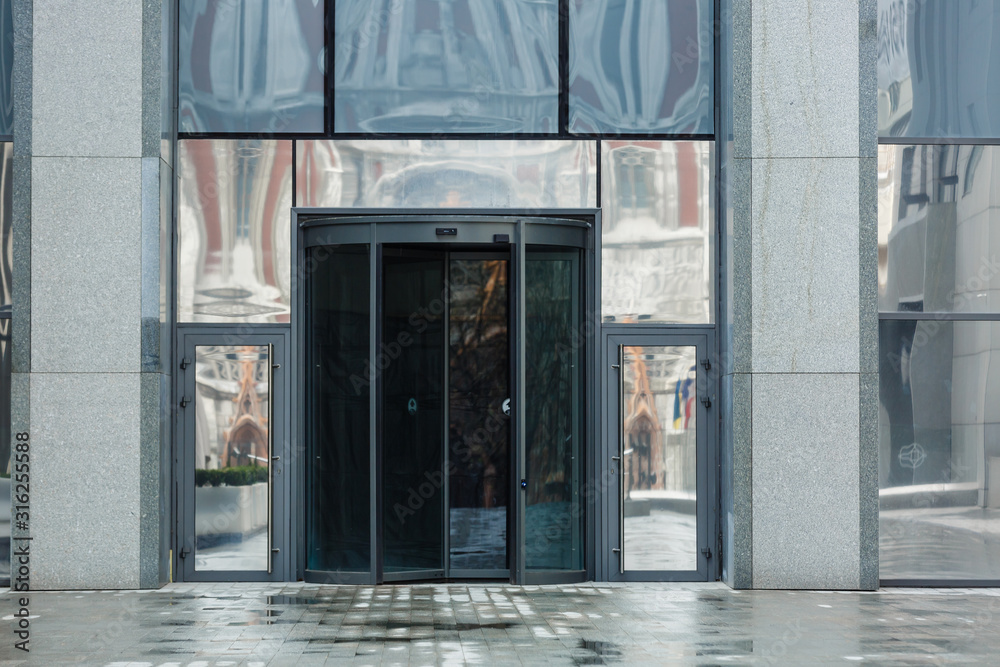 Revolving glass door of modern office business center. Entrance of the commercial building Revolving glass door of modern office business center. Entrance of the commercial building
