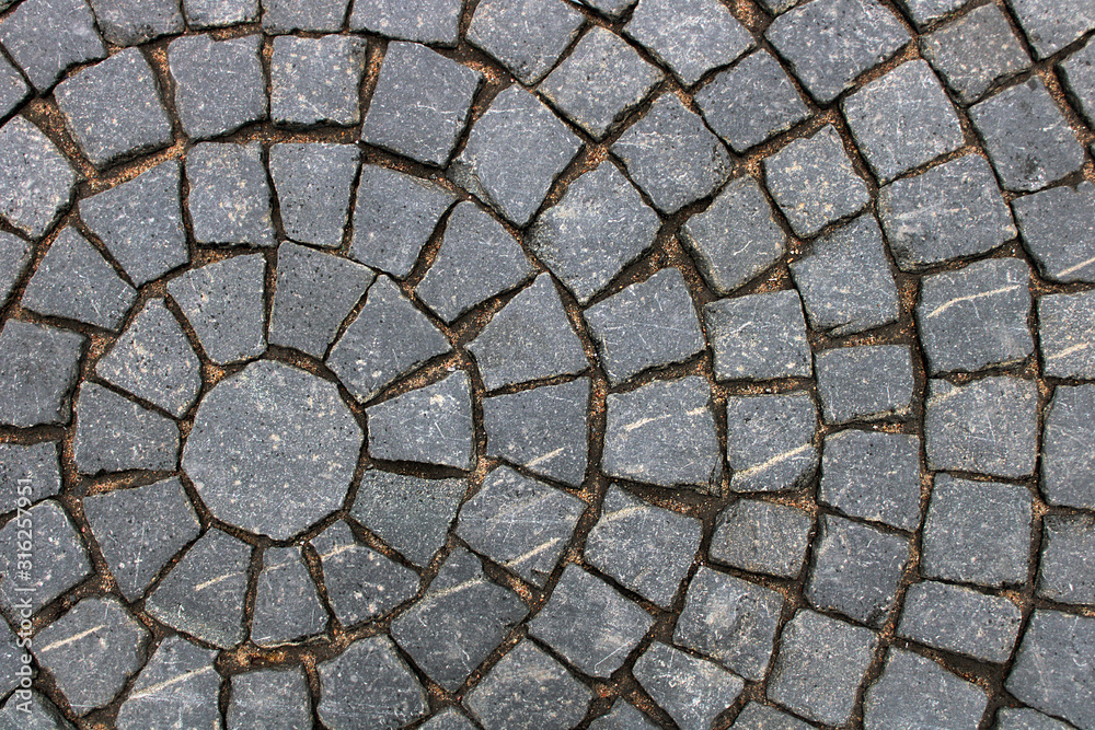 Old cobblestone road with soil between the stones. Texture and background. Business cards, advertising, printing. Old cobblestone road with soil between the stones. Texture and background. Business cards, advertising, printing.