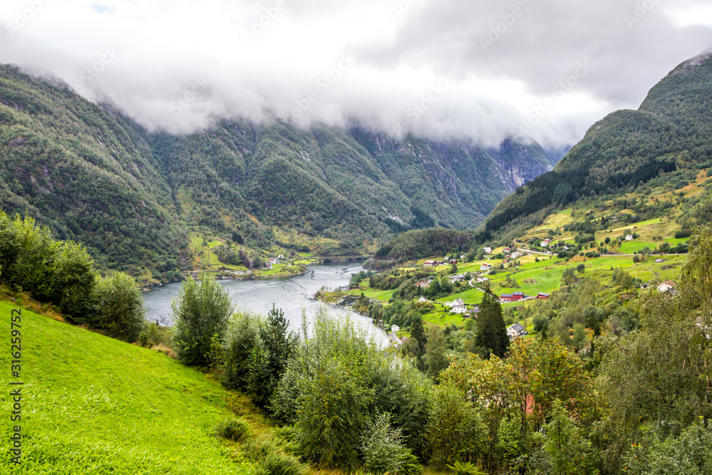 Steinsdalsfossen waterfall and meadow in the valley in Norway
