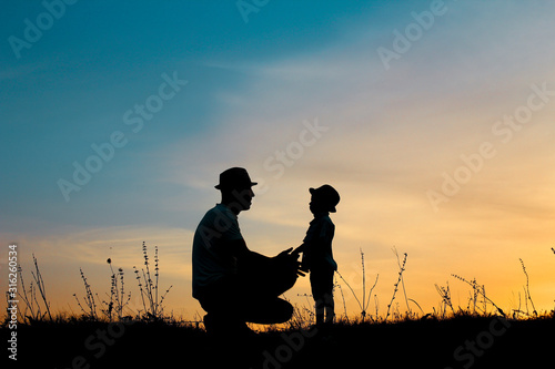 silhouette of father and son play on sunset
