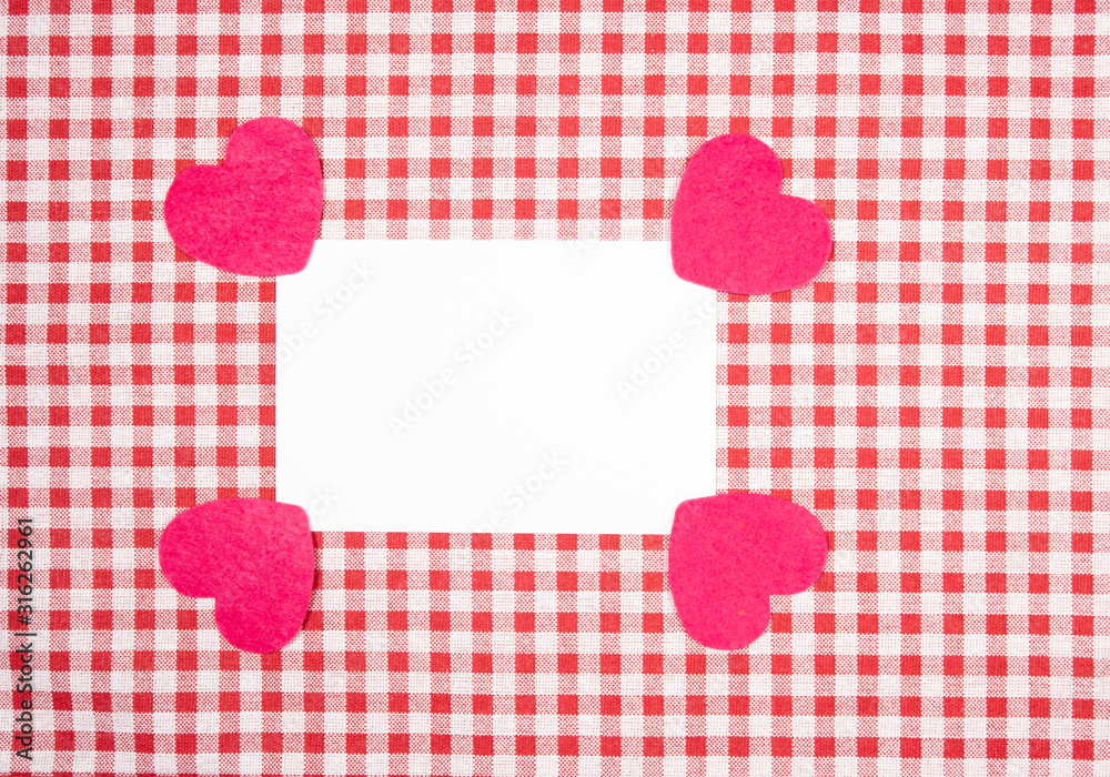 background with red and white Vichy fabric for valentine's day with red and pink hearts and a white card to put the text. valentines day concept background with red and white Vichy fabric for valentine's day with red and pink hearts and a white card to put the text. valentines day concept