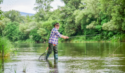 rural sports. retired bearded fisher. Trout bait. mature man fly fishing. man catching fish. fisherman with fishing rod. summer weekend. Big game fishing. hobby and sport activity. pothunter