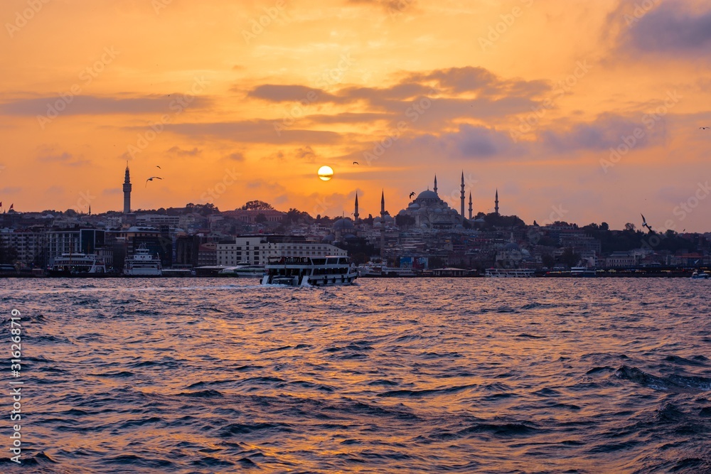 the Bosporus mosque at sunset, the ships paint the sky