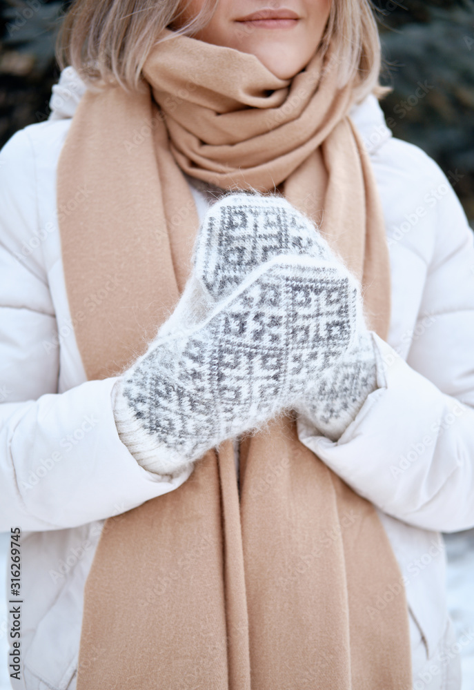 Hands in Knitted Mittens. Winter lifestyle. Wearing Stylish Warm Clothes. Woman in warm clothes