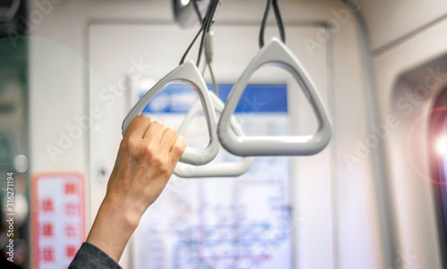 Woman's Hand Hold on to a Handle Bar on a Public Transportation while Standing.
