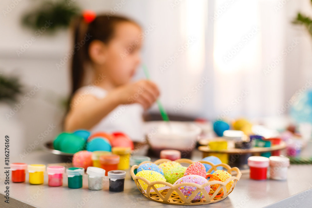 Easter eggs in nest on color wooden background