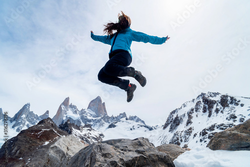 A hiker woman jumping on the base of Fitz Roy Mountain in Patagonia, Argentina
