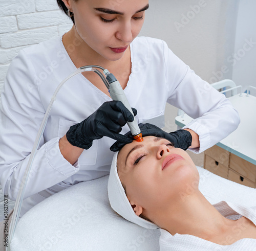 Face Skin Care. Closeup Of Woman Face Cleansing At Cosmetology clinic, vacuum cleaning photo