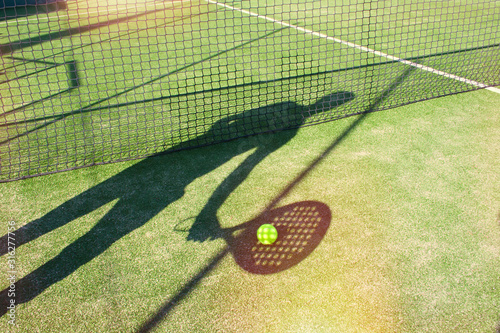 Shadow from padel racket and player on the ball on the court