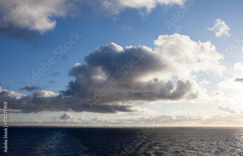 Blue sky with clouds and sun reflection in water with place for your text. anazing clouds, mist in the sky