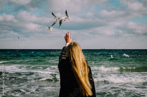 Girl catches a hand seagull.