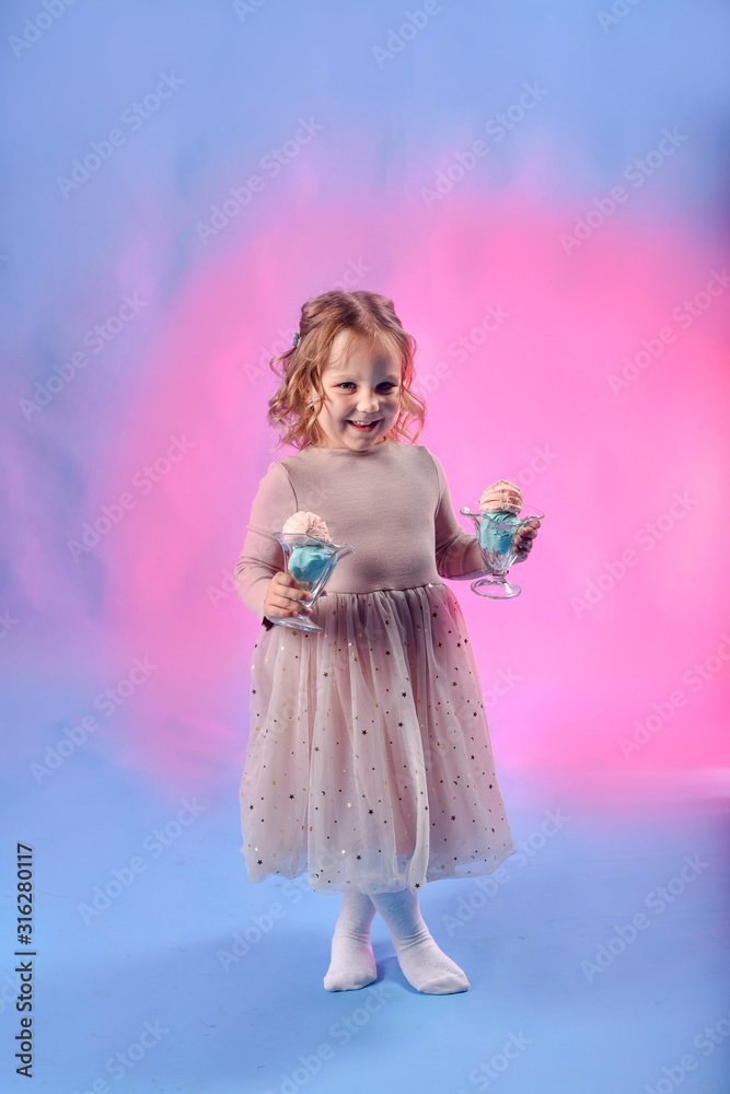 Cute girl with bright bubble gum ice cream of pink and blue color. Against the background of a neon color. Blue and pink light. The concept of summer, disco