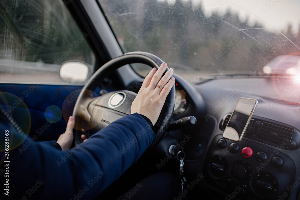 woman drives a car, holds the steering wheel on a trip.