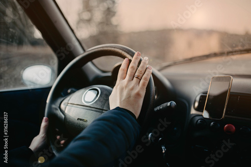 female hands on the steering wheel of a car, girl travel trip
