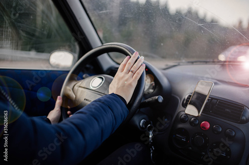 woman drives a car, holds the steering wheel on a trip. © velimir