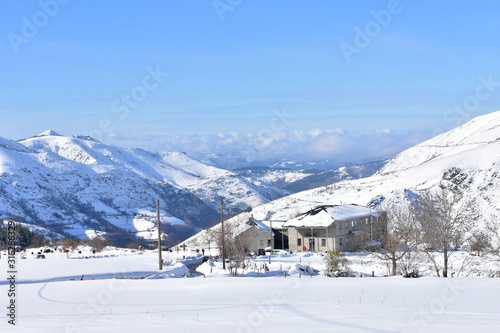 Winter landscape with snowy mountains, shelter and valley with blue sky. Piornedo village, Ancares, Lugo, Galicia, Spain.