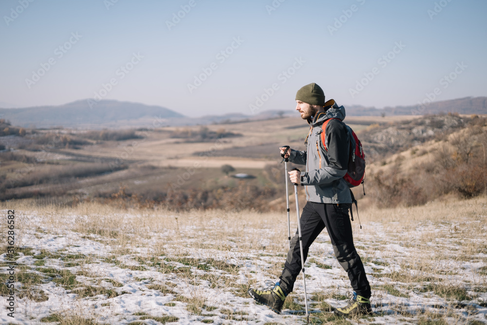 Side view of tourist walking on field with mountain view