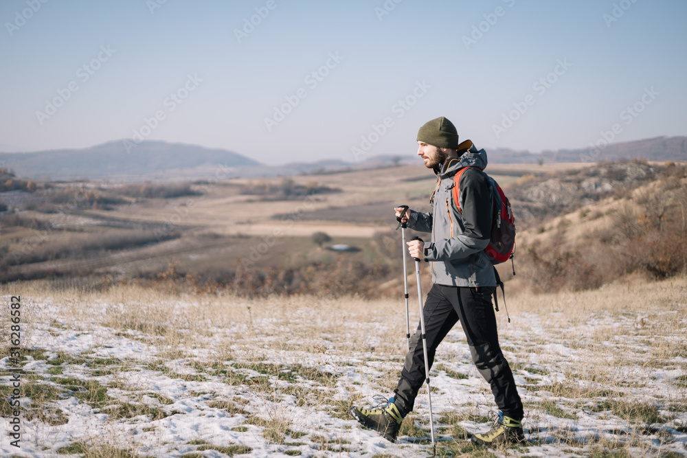 Naklejka premium Side view of tourist walking on field with mountain view