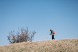 Man walking through field against blue sky
