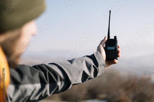 Man holding two-way radio for hiking in the air