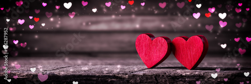 Two Wooden Hearts On Rustic Table With Colorful Heart Shaped Bokeh - Valentine's Day Concept