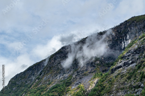 Mystic heavy clouds on green rocky Norway hills 