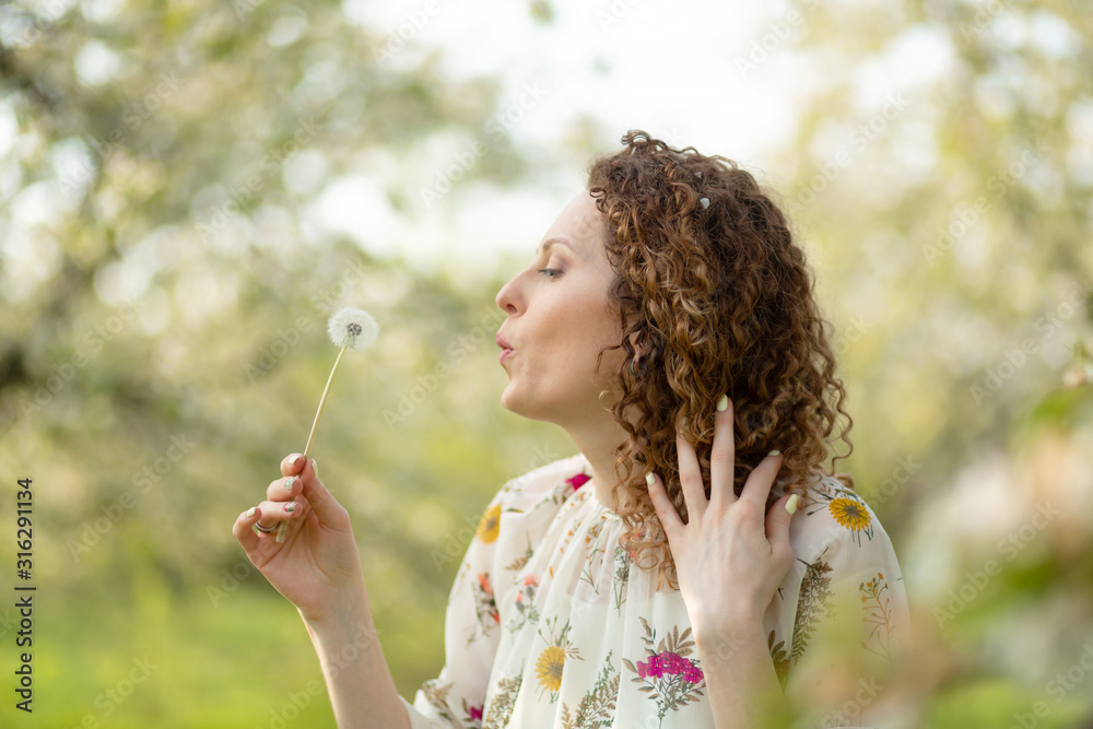Pretty girl blowing dandelion in summer park. Green grass beautiful nature. Pure emotion. Pretty girl blowing dandelion in summer park. Green grass beautiful nature. Pure emotion.