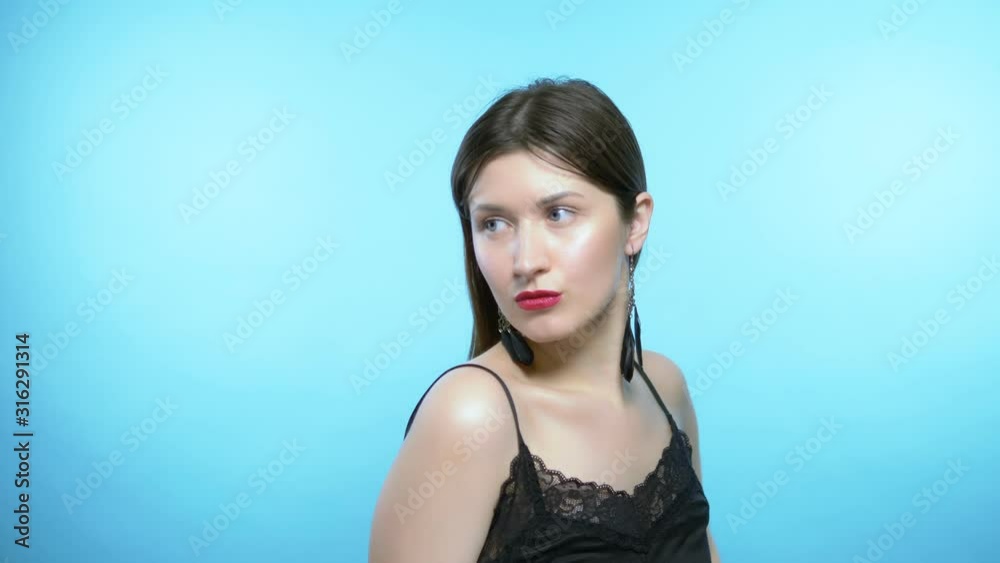 portrait of a beautiful girl. blue background. the girl wears earrings portrait of a beautiful girl. blue background. the girl wears earrings