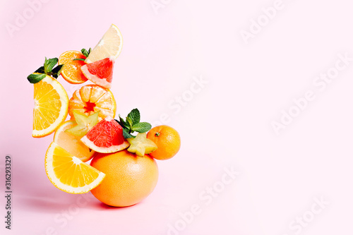 Fresh fruits on pink background, copy space