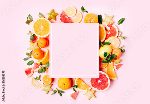 Fototapeta Naklejka Na Ścianę i Meble -  Fresh citrus fruits formed frame on pink background. Copy space. Mock up
