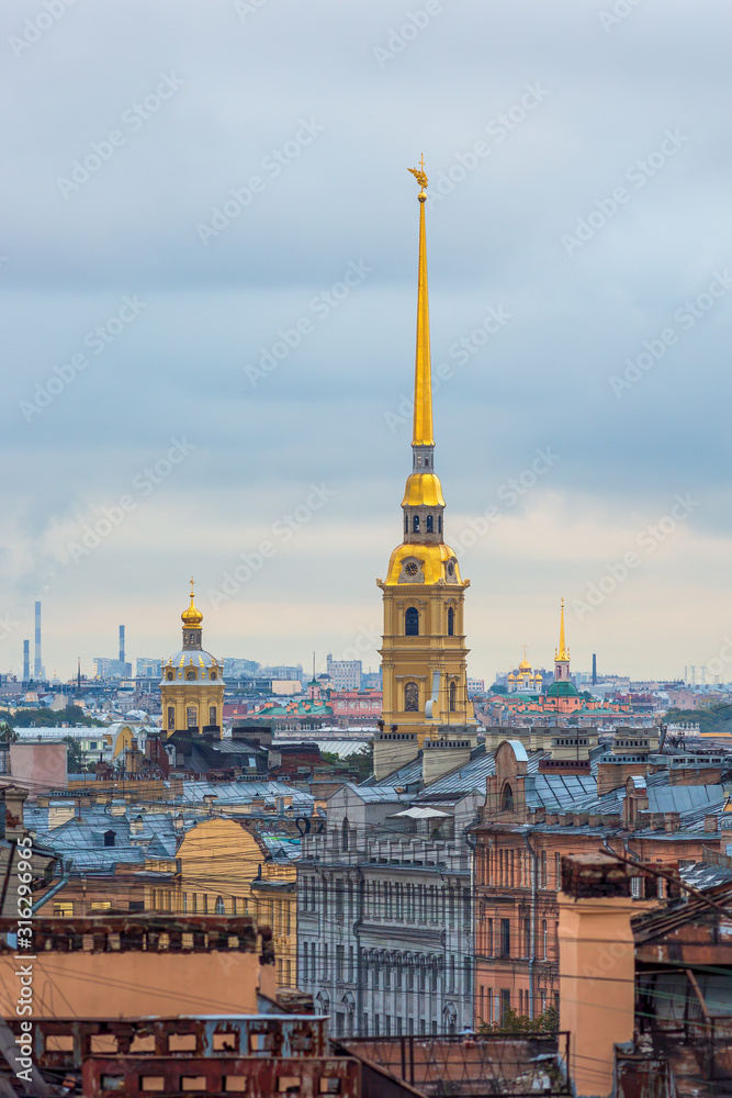 Beautiful top view of the historic city center of St. Petersburg. Cityscape with roofs of buildings and the high bell tower of the Peter and Paul Cathedral. Landmarks of Saint-Petersburg, Russia.