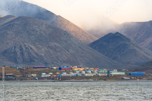 The majestic Arctic landscape with the Eskimo village of Sireniki, located on the coast of the Bering Sea, surrounded by mountains. Chukotka, Far East of Russia. photo