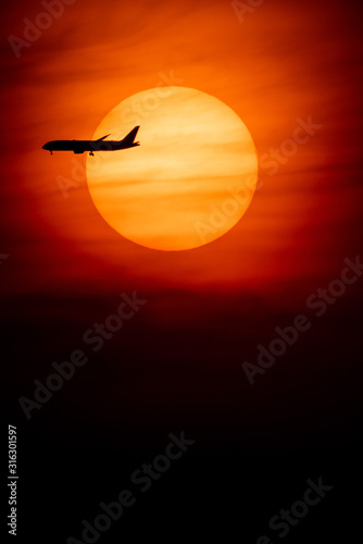 Silhouette of passenger airplane with the morning sunrise background