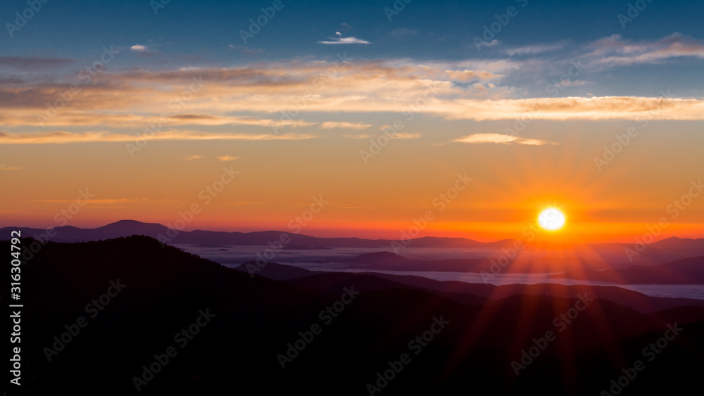 Sun peaks over the mountain peaks of the Blue Ridge Parkway Sun peaks over the mountain peaks of the Blue Ridge Parkway