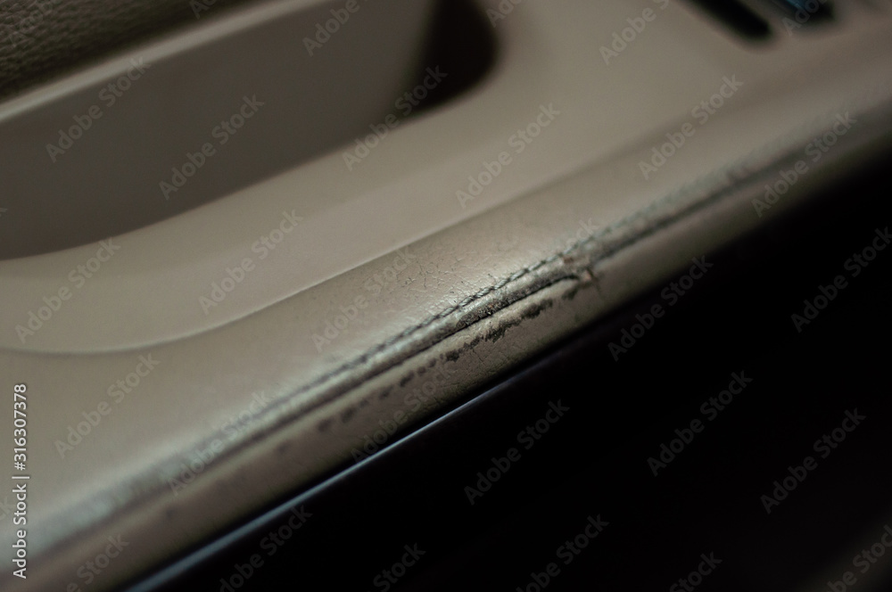 The armrest of the driver's door of the car sheathed in beige leather. Shabby leather interior. The armrest of the driver's door of the car sheathed in beige leather. Shabby leather interior.