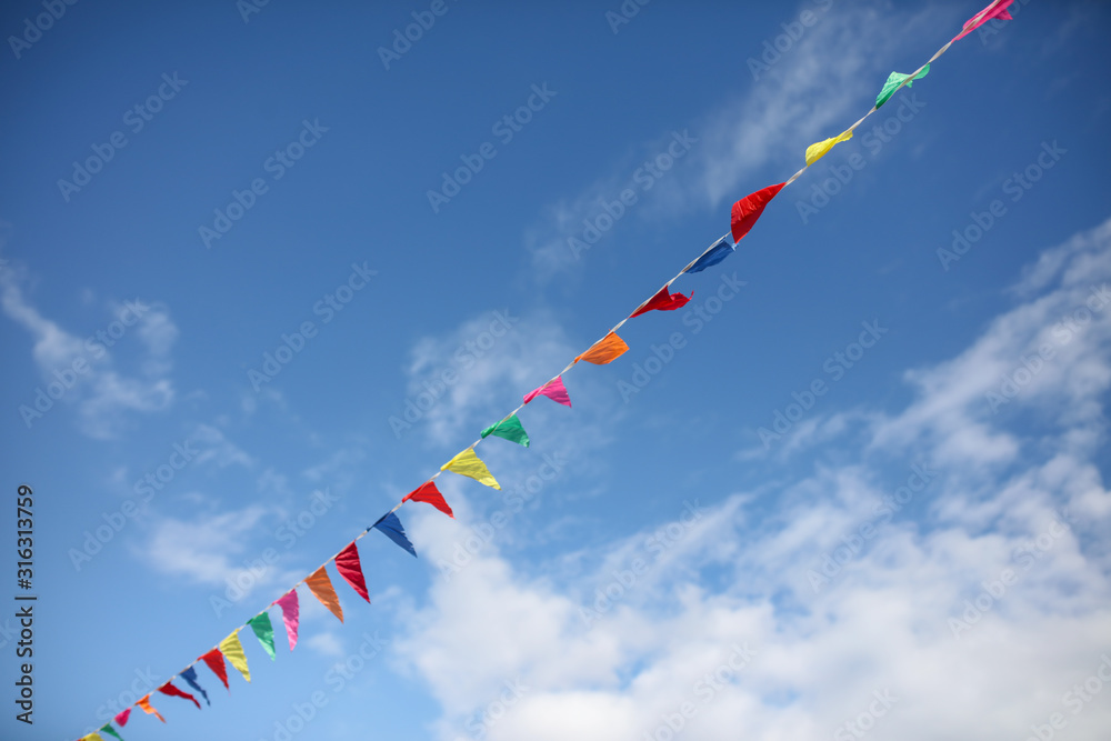 Multi-colored flags on a background of blue sky Multi-colored flags on a background of blue sky