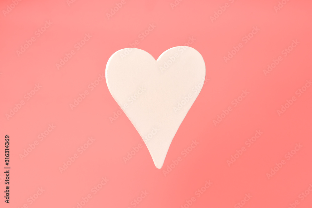 Heart. One white wooden heart on a pink background in the center. Valentine's day, February 14.