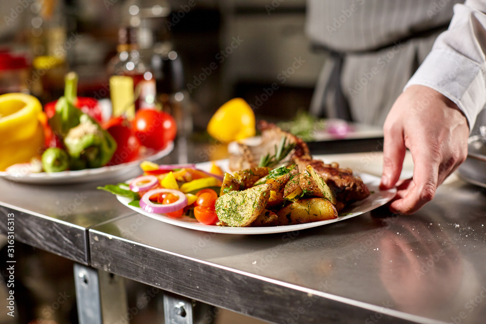 the chef prepares in the restaurant. Grilled rack of lamb with fried potatoes and fresh vegetables