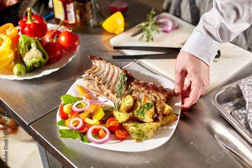 the chef prepares in the restaurant. Grilled rack of lamb with fried potatoes and fresh vegetables