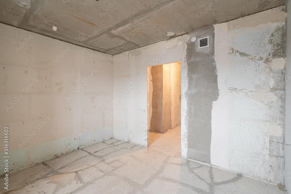 Empty interior for design, gray concrete wall. Empty room. Space for text and picture. Concrete walls, slabs, interior of a new residential building. Partitions in a new apartment.