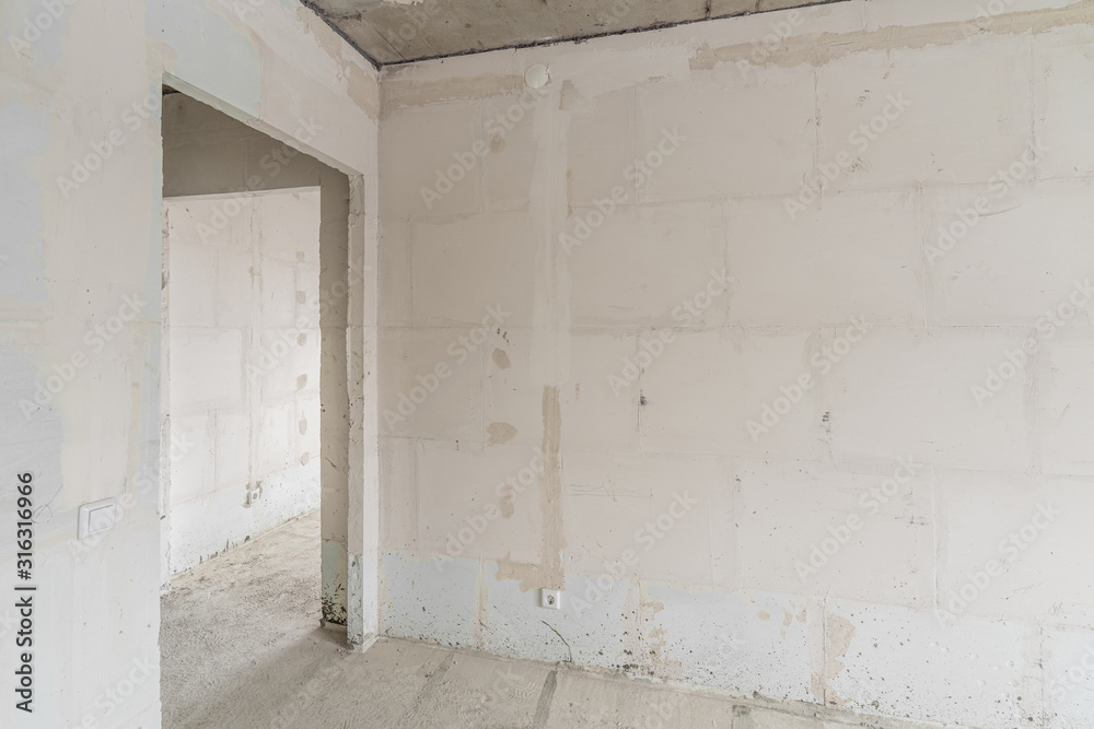Empty interior for design, gray concrete wall. Empty room. Space for text and picture. Concrete walls, slabs, interior of a new residential building. Partitions in a new apartment. Empty interior for design, gray concrete wall. Empty room. Space for text and picture. Concrete walls, slabs, interior of a new residential building. Partitions in a new apartment.
