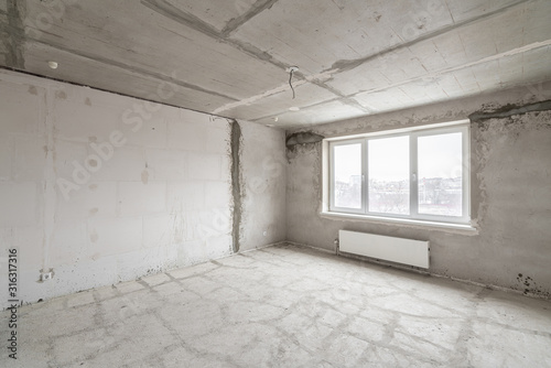 Empty interior for design, gray concrete wall. Empty room. Space for text and picture. Concrete walls, slabs, interior of a new residential building. Partitions in a new apartment.