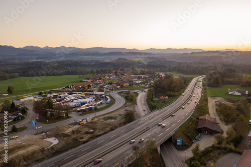 Top down aerial view of freeway interstate road with moving traffic cars in rural area.