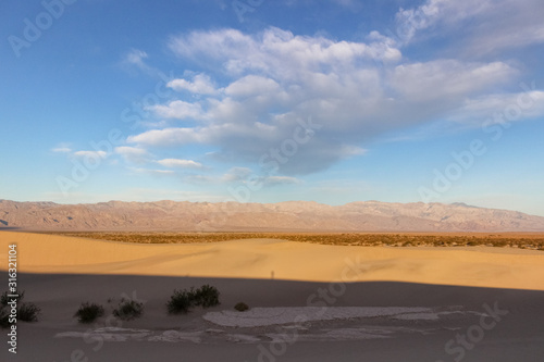 clouds above sand dunes in desert of Death Valley National Park, California