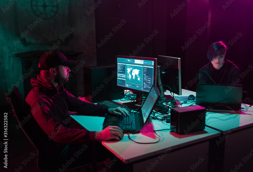 Wanted hackers coding virus ransomware using laptops and computers in the basement. Cyber attack, system breaking and malware. Wanted hackers coding virus ransomware using laptops and computers in the basement. Cyber attack, system breaking and malware.